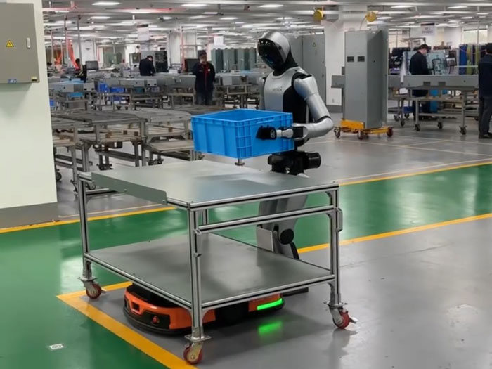 Figure 4.3: UBTECH's official newsroom photograph of a Walker S2 on-site test in a Hitachi Elevator workshop. The tote, worktable, and surrounding equipment establish the test context, but the image is not independent evidence of repeat success or intervention-free uptime. Source: UBTECH and Hitachi partnership news, fair use for academic review