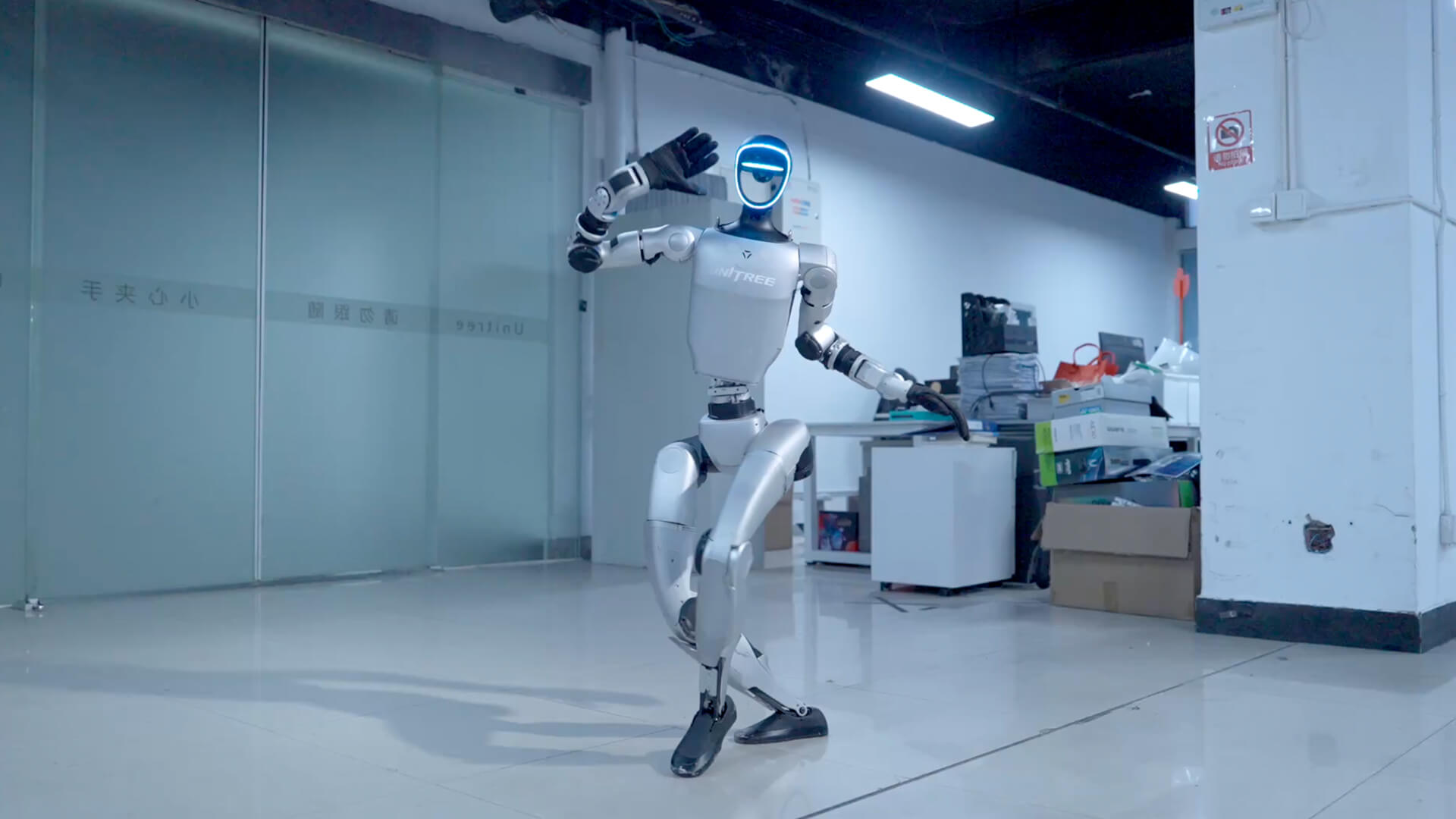 Figure 4.2: A laboratory scene from Unitree's official G1 product video. It shows the whole-body structure and a dynamic pose, but does not establish manufacturing-task repeatability, compatibility with external research stacks, or field deployment. Source: Unitree G1 product page, fair use for academic review
